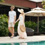 Couple enjoying a relaxing walk at a tropical resort, representing the serene ambiance offered by eco-friendly hotels.