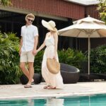 Couple enjoying a relaxing walk at a tropical resort, representing the serene ambiance offered by eco-friendly hotels.